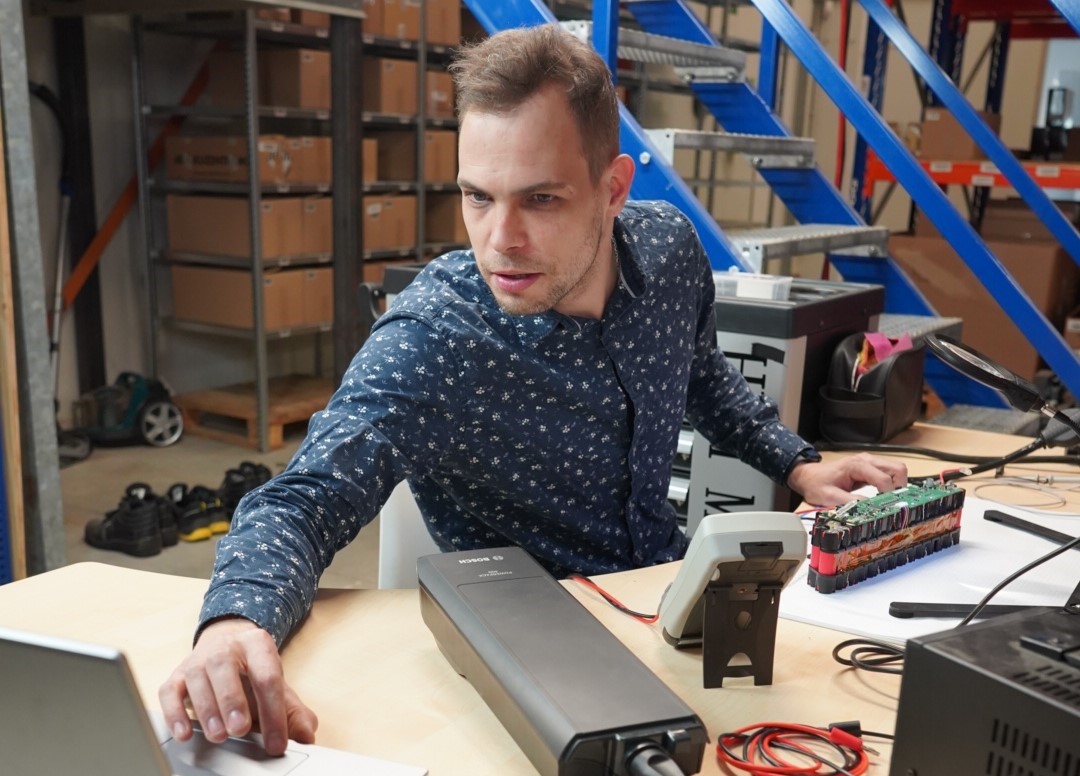 Esta imagen muestra al responsable eléctrico de e-bikeaccu.co.uk realizando cuidadosamente las pruebas de las nuevas baterías para bicicletas.